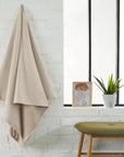 Foutas éponge unie beige sahara étendue dans une salle de bain
