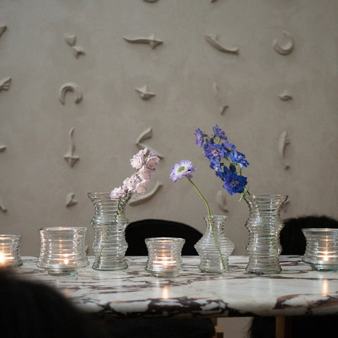 Photo avec des vases fleuris et des bougeoirs sur une table en marbre